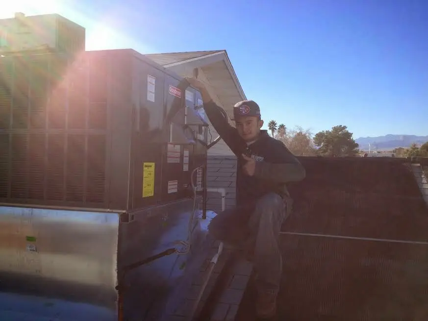 HVAC technician performing AC Tune-Up on a rooftop unit in Mills River